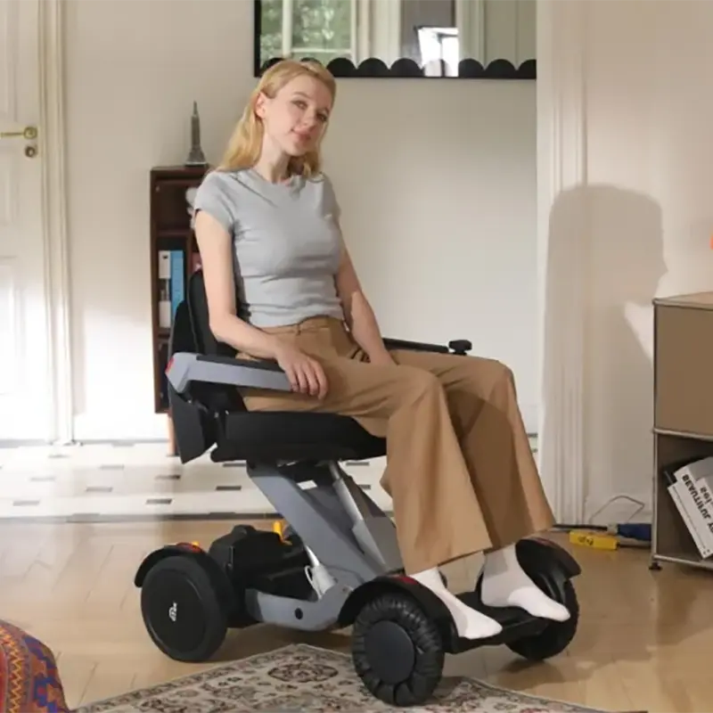 Woman using a Mobility World Ltd UK: XSTO M4 Electric Powered Wheelchair in a home setting