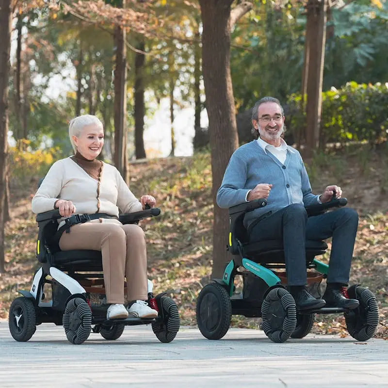 Two people using Robooter E60 Pro All Terrain Electric Folding Powerchair in a park setting