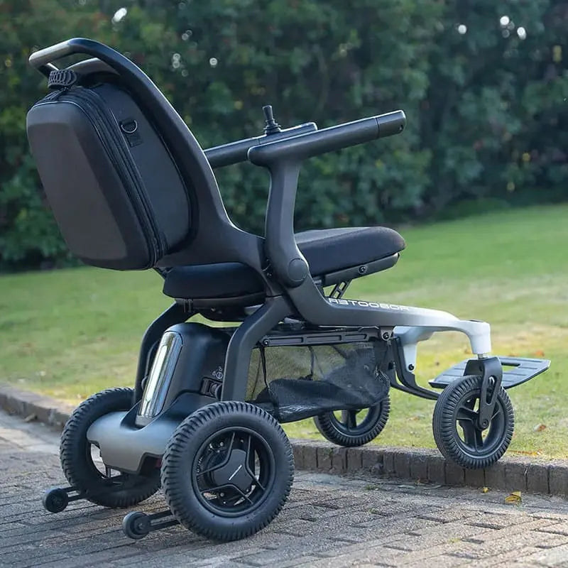 Robooter E80 Ultra Carbon Fiber Lightweight Folding Powerchair on a paved path with grass and trees in the background
