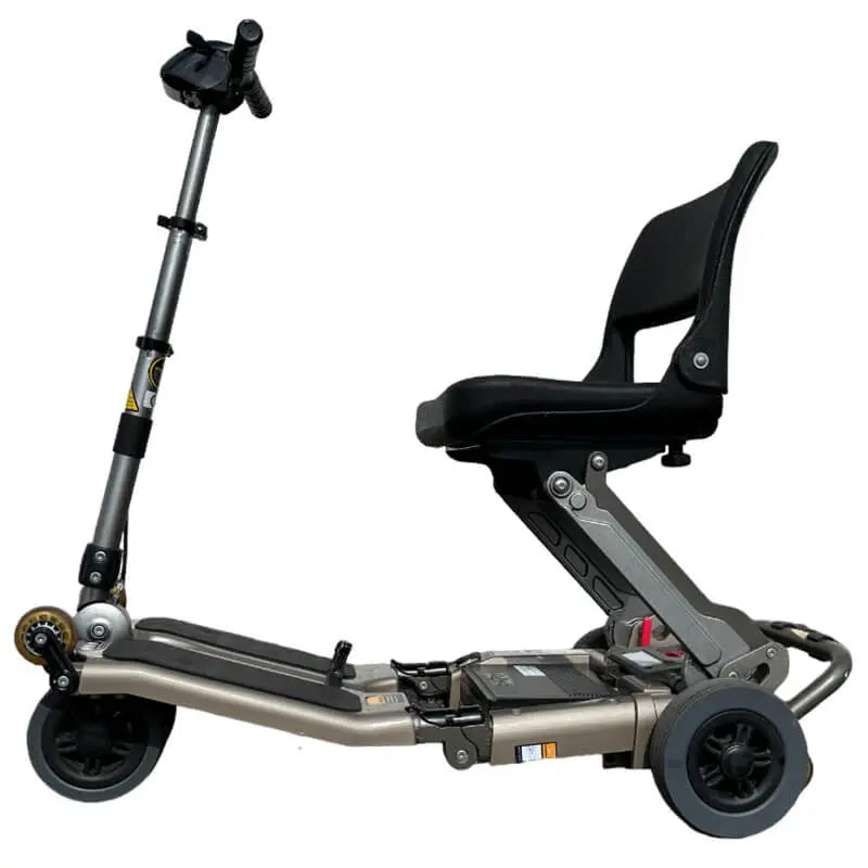 The Approved Used Freerider Luggie Mobility Scooter is versatile and lightweight, easily folding for transport. It features a Lithium Polymer battery like those in modern electric cars. With 13-inch tyres for outdoor use, the Standard Luggie is the world's most compact, folding to H66cm x W45cm x L39.5cm. It has 6-inch front and 7-inch rear tyres for varied terrains, a range of 11 miles, and weighs just 23kg including the battery, making it easy to lift into vehicles.
