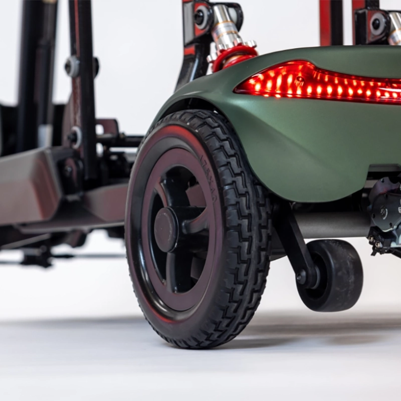 Close-up of a green Smarti Plus Lightweight Auto-Folding Mobility Scooter with a red light on a white background