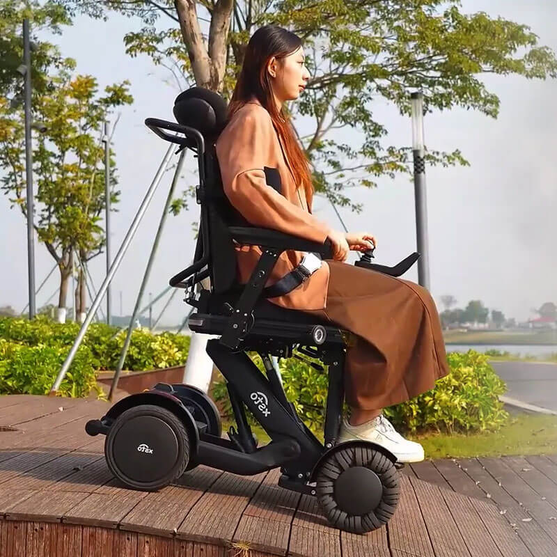 Person using XSTO M4 Pro Smart Self Balancing Powered Wheelchair outdoors on a wooden deck with greenery in the background