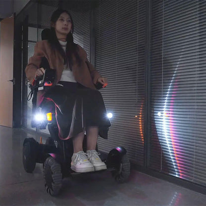 Person riding a XSTO M4 Pro Smart Self Balancing Powered Wheelchair with lights on a dark street.