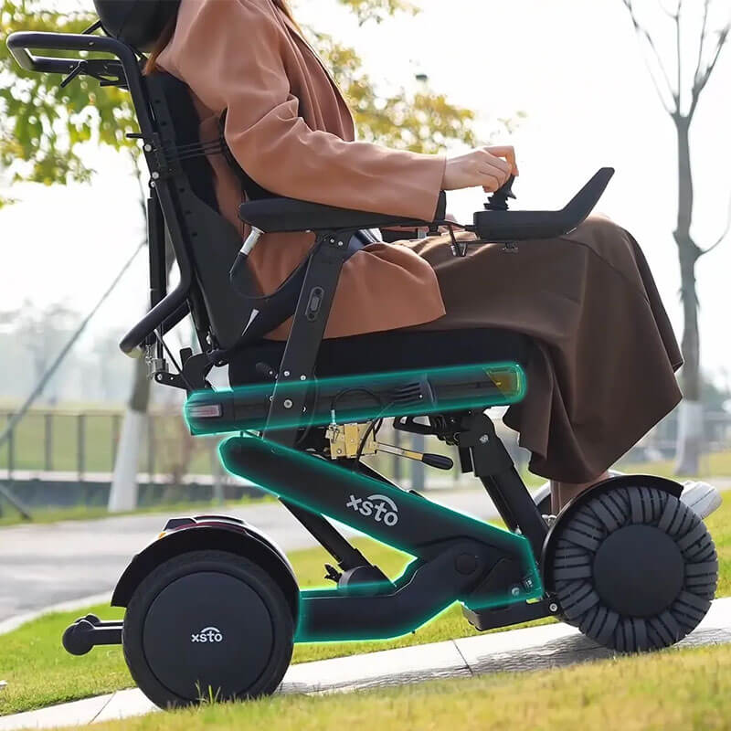 Person using XSTO M4 Pro Smart Self Balancing Powered Wheelchair with 'xsto' branding outdoors.