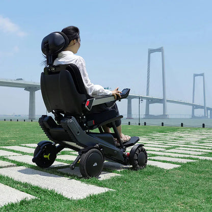 Person using a Xsto X12 All-Terrain Mobility Robot Powered Wheelchair
in an outdoor setting with a bridge in the background