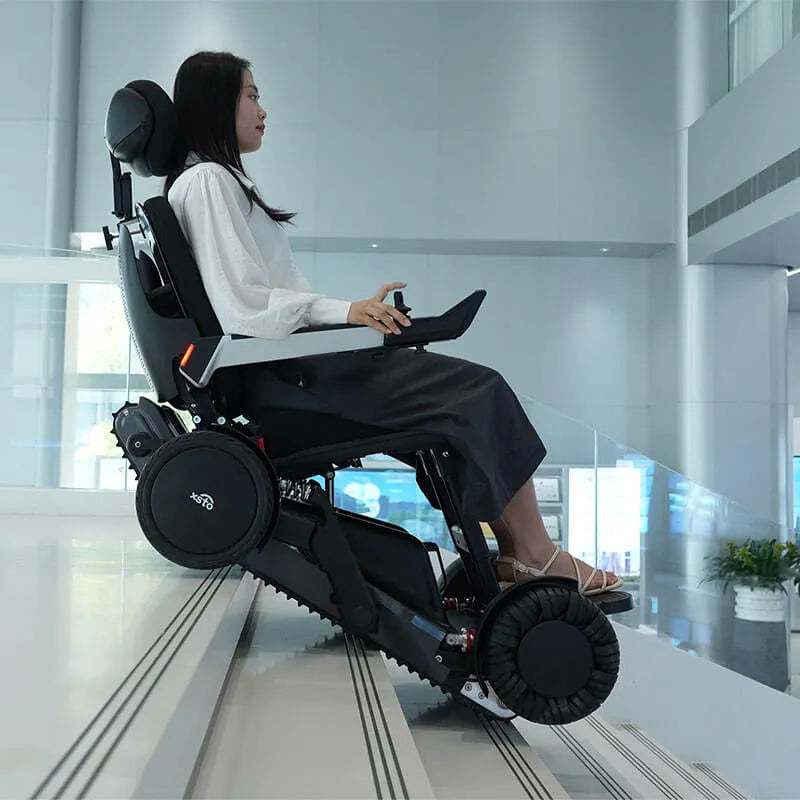 Person using a modern Xsto X12 All-Terrain Mobility Robot Powered Wheelchair in a futuristic building interior.