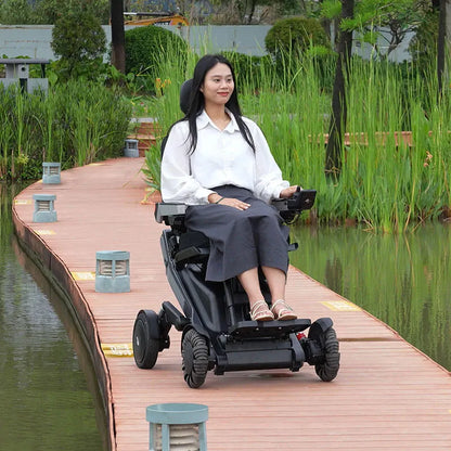 Woman using a Xsto X12 All-Terrain Mobility Robot Powered Wheelchair
 on a wooden path by a lake