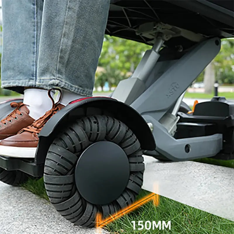 Person using XSTO M4 Electric Powered Wheelchair with large wheels on a concrete surface.