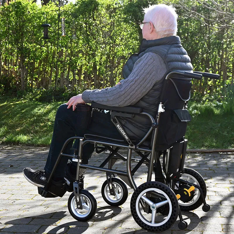 Man in a Buddy Pro Folding Powerchair Wheelchair outdoors on a sunny day